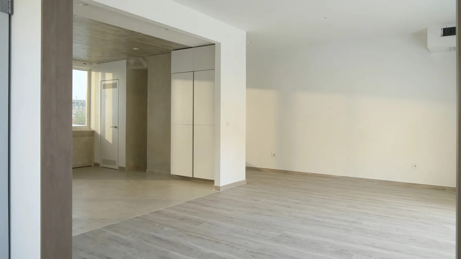 The same kitchen and living area after LVP installation — wide-plank waterproof flooring throughout the open plan